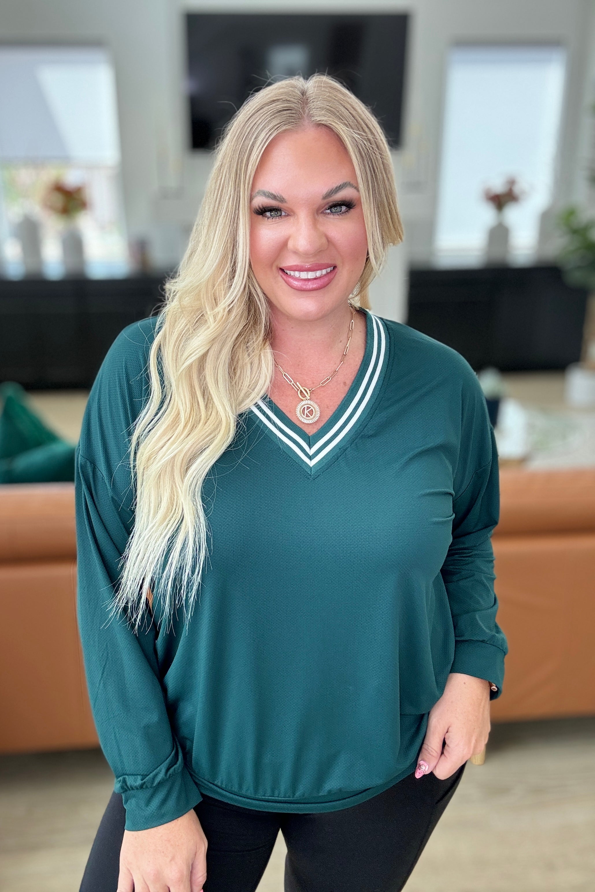 All Out Comfort V-Neck Pullover in Midnight Green featuring a contrast V-neckline, drop shoulders, banded cuffs and hem. High-stretch, breathable nylon fabric.