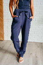 zoomed in front view of Lysa Satin Stripe Lounge Pants in Smoky Navy, high-rise, elastic waistband, satin tuxedo stripe, tapered leg, scuba knit fabric, shown in various sizes